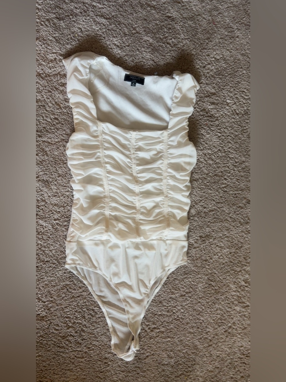 White corset style bodysuit with ruffles and lace up back.